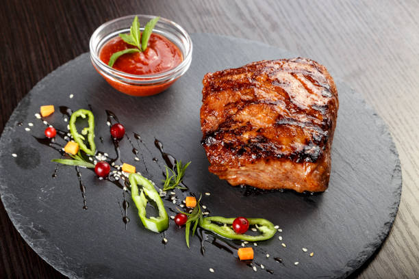 istock Steak on slate board. standing next to a gravy boat with ketchup. 1222417841