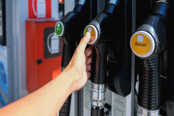 Close up shot of female hands holding a diesel fuel pump handle to refueling her car during Coronavirus outbreak