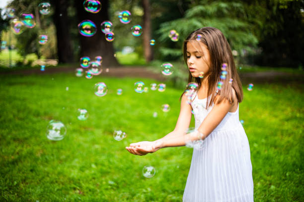 istock Cute small girl playing with soap bubbles in nature 1222422741