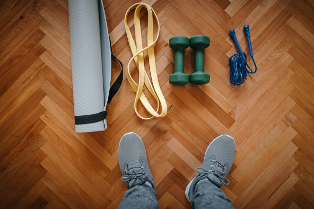 istock Low section of man with exercise equipment on hardwood floor 1222422932