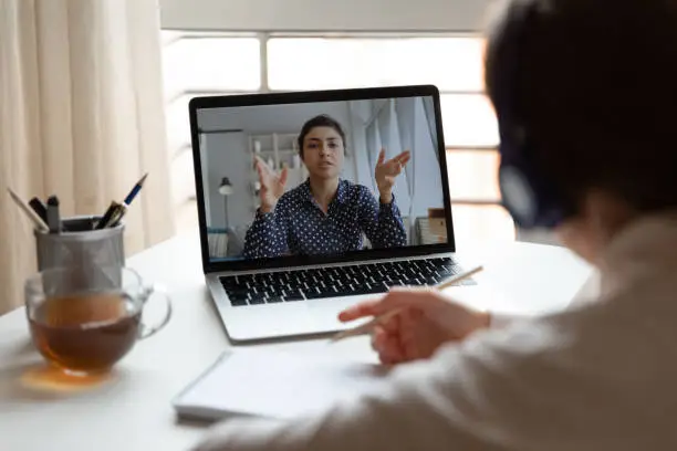 Photo of Male employee talk on video call with female colleague