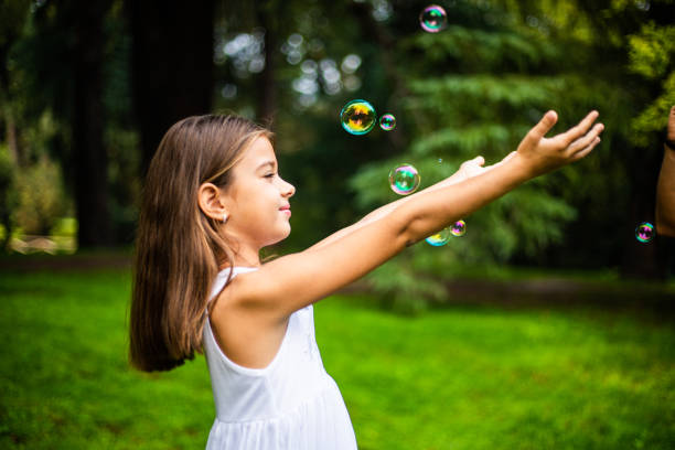 istock Cute small girl playing with soap bubbles in nature 1222423191