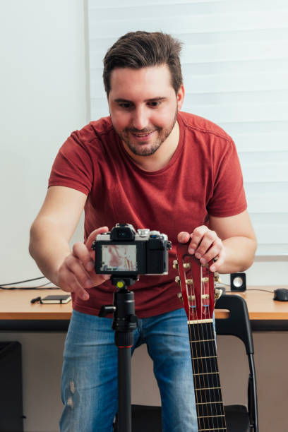 Blogger preparing the camera to record the guitar lesson from his home studio