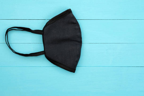 istock Black cotton mask folded in half. Do-it-yourself face mask made of fabric. 1222427543