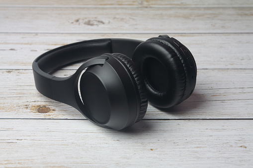 Modern professional headphones isolated on wooden table