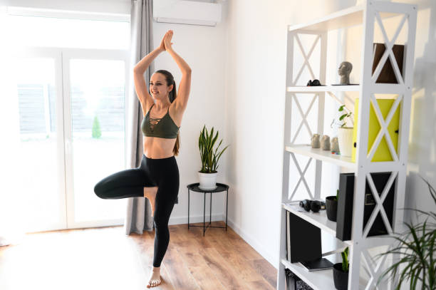 istock Young positive woman is practicing yoga at home 1222430856