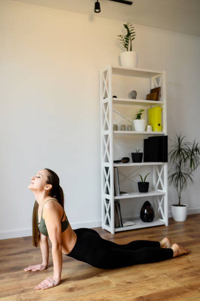 istock Young positive woman is practicing yoga at home 1222430878