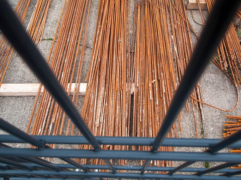 High angle view through a lattice fence on stored monier iron at a construction site in Berlin.