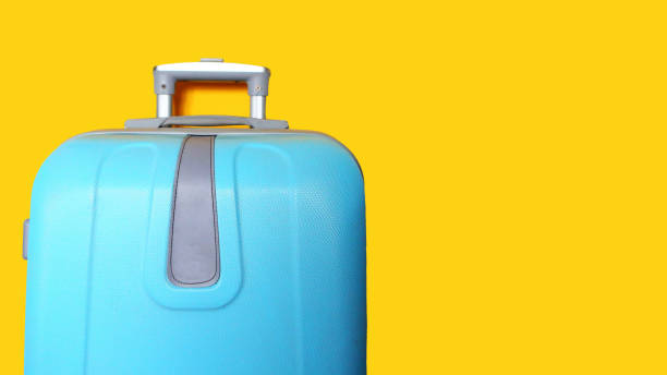 istock Blue suitcase isolated on yellow. Travel concept, banner. Copy space for the text 1222432377