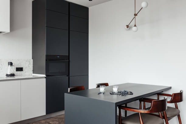 istock bright kitchen with dark table, convenient location of kitchen accessories and equipment, modern style, White walls, marble working surface and parquet floor. There s a glass of milk on the table and a blueberry 1222435351