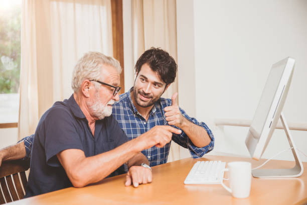 istock young man or son teaching his grandfather elderly dad learning to using computer at home. 1222435674