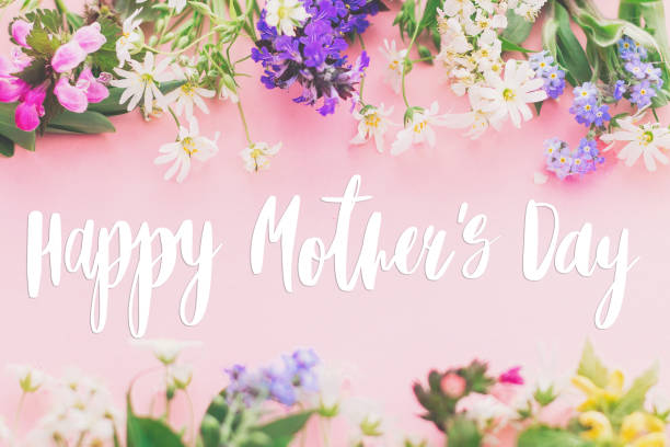 istock Happy Mother's day text on colorful blooming spring flowers frame flat lay on pink background. Floral greeting card. Happy Mothers day concept. 1222436372