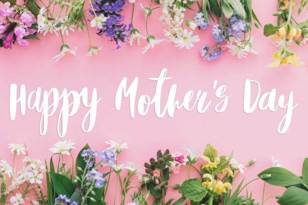 istock Happy Mother's day text on colorful blooming spring flowers frame flat lay on pink background. Floral greeting card. Happy Mothers day concept. 1222436571