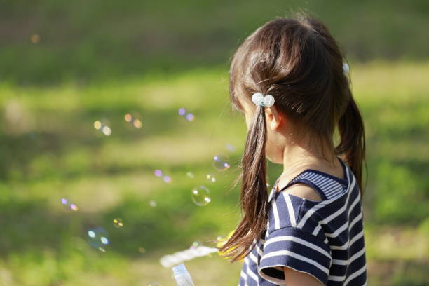 istock Japanese girl playing with bubble in the green (appearance from behind) (5 years old) 1222436962