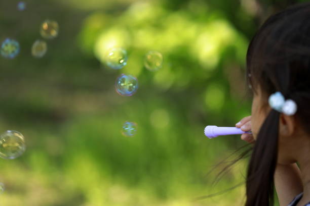 istock Japanese girl playing with bubble in the green (appearance from behind) (5 years old) 1222437018