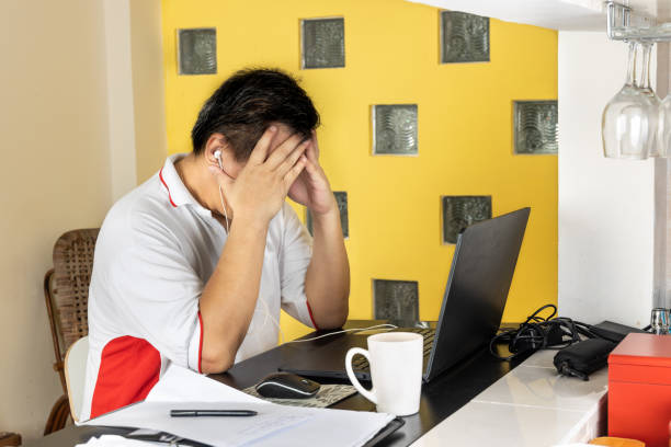 istock Matured Asian business man with both hands on forehead in stressful expression in work from home video conference call 1222437812