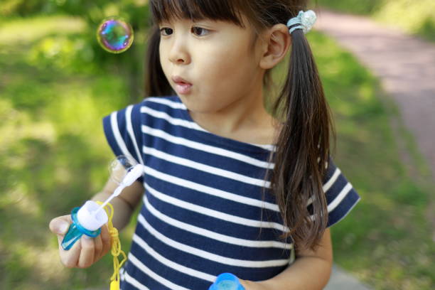 istock Japanese girl playing with bubble in the green (5 years old) 1222437953