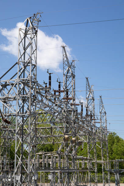 istock Structures of electrical power substation reaching above the treeline, blue sky with white clouds 1222439067