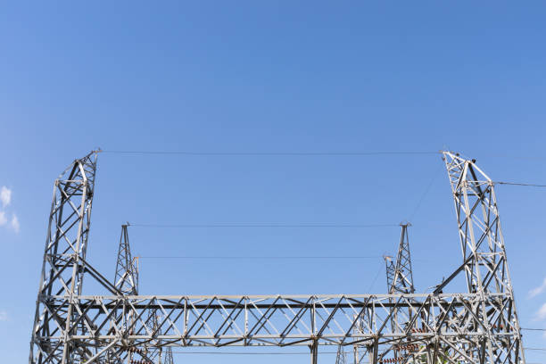 istock Metal electrical power transfer station trusses centered against a blue sky, creative copy space 1222439072