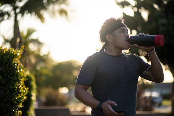 istock Filipino man working out at home Drinking Water 1222441117