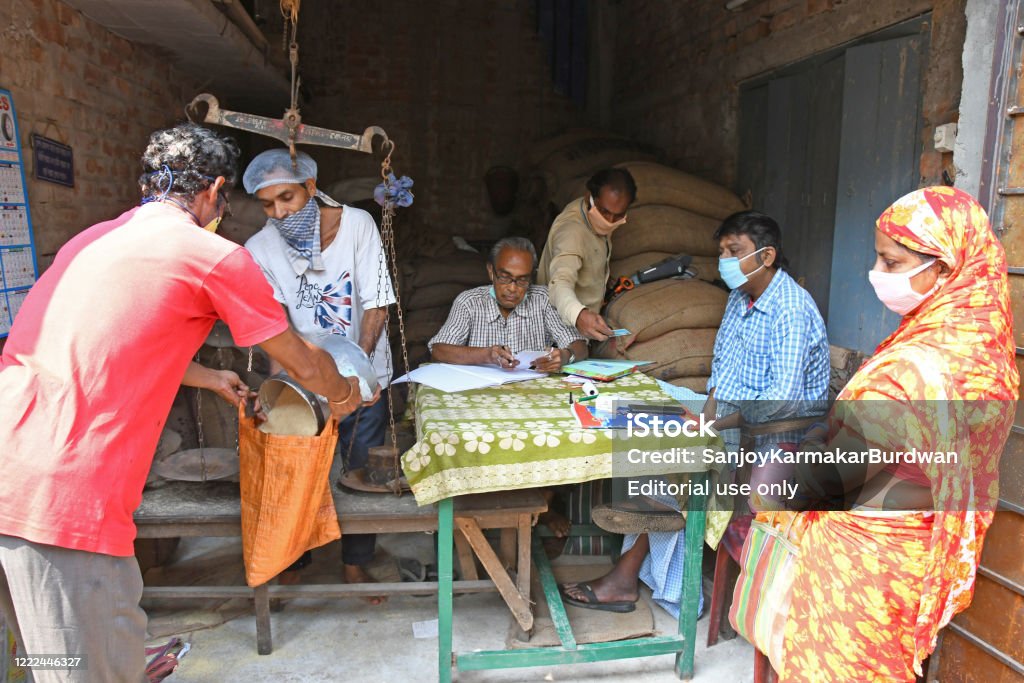People in a queue to collect food grains at a ration shop in Burdwan town during the lock down period due to Novel Coronavirus (COVID-19) outbreak. Burdwan Town, Purba Bardhaman District, West Bengal / India - May 05, 2020: People in a queue to collect food grains at a ration shop in Burdwan town during the lock down period due to Novel Coronavirus (COVID-19) outbreak. At Burdwan Town, Purba Bardhaman District, West Bengal, India. India Stock Photo