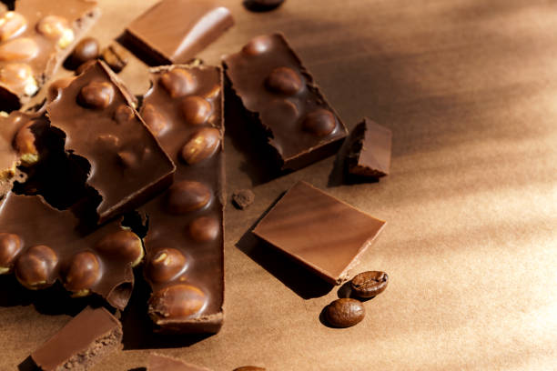 fermez-vous vers le haut du chocolat au lait avec des noisettes sur le fond brun. copier spcace pour le texte - brown chocolate candy bar close up photos et images de collection