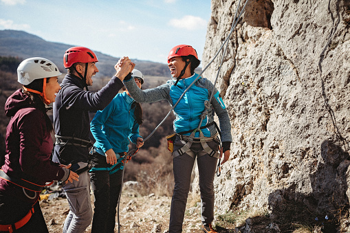 Female rock climbers giving high five after a successful climb