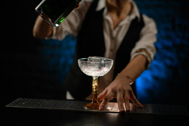 istock Close-up bartender begin to pour drink into glass 1222451212