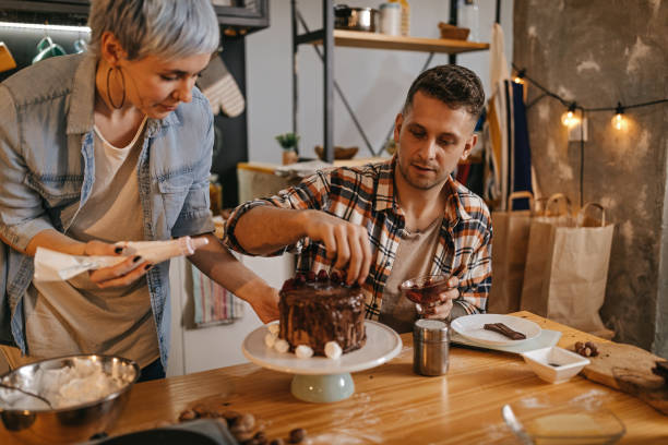 istock Couple decorating a cake at home 1222451224