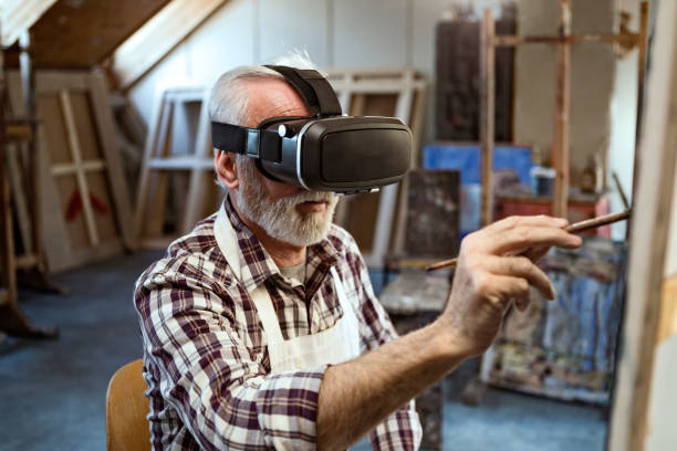 istock Senior man wearing VR headset painting picture 1222452165