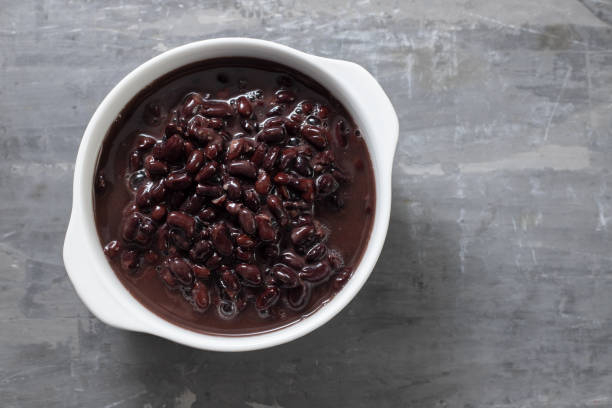 boiled black beans in white bowl on ceramic background