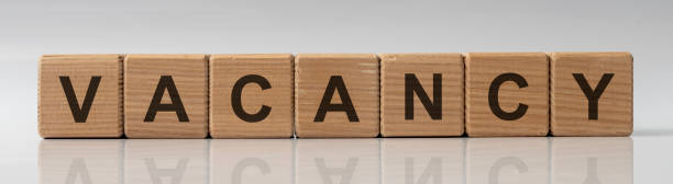 istock Vacancy word written on wood blocks on white grey background with reflection 1222455191
