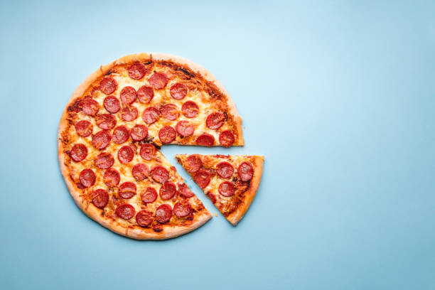 Pizza pepperoni above view. Homemade pizza. Pepperoni pizza on a blue background top view. Traditional italian food. Flatlay with a home-baked pizza with hot pepperoni and mozzarella. light blue photos stock pictures, royalty-free photos & images