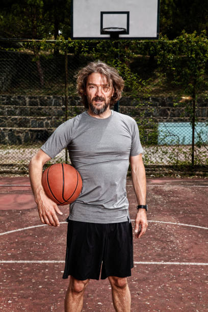 istock Handsome mature man holding a basketball with his arm. 1222455295