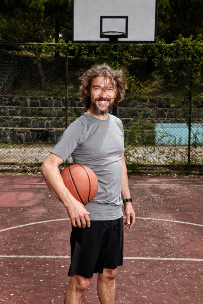 istock Handsome mature man holding a basketball with his arm. 1222455378
