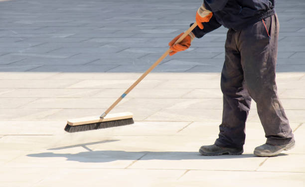 istock Pavement construction worker filling the block joints with sand using long broom 1222455389