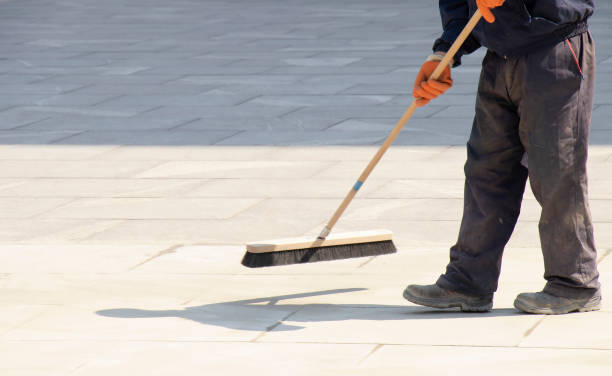 istock Pavement construction worker filling the block joints with sand using long broom 1222455467