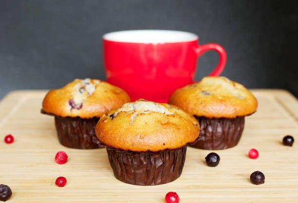 Red Cup and Blueberry Muffins on a board with a dark background.