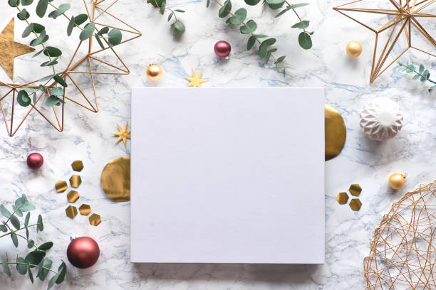 istock Christmas frame with fresh eucalyptus twigs and golden geometric decorations - hexagons, trinkets and wire shapes. Flat lay, top view on white marble background with copy-space, place for your text.. 1222457381