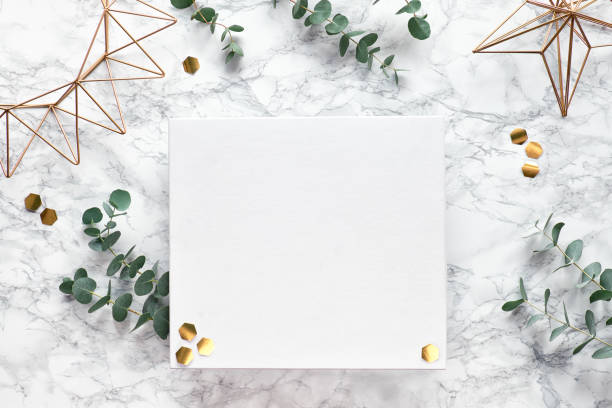 istock Christmas frame with fresh eucalyptus twigs and golden geometric decorations - hexagons and geometric wire shapes. Flat lay, top view on white marble background, place for text, copy-space. 1222457509
