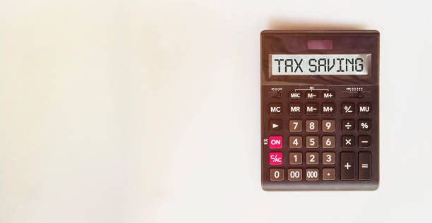 istock Calculator with text Retirement Plan. Calculator, currency, book, bills and computer keyboard on wooden table. Business, finance, banking conceptual. 1222458935