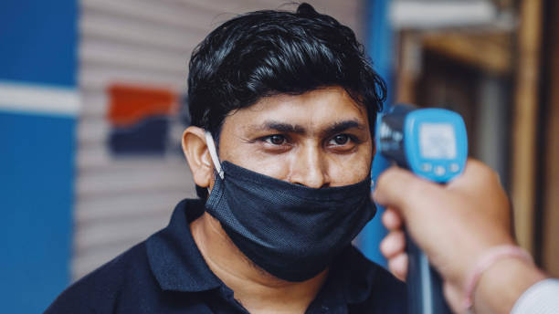 Coronavirus screening with Infrared thermometer gun at checkpoints. Screening of people for Covid-19 coronavirus symptoms. Temperature checkpoints at various place, close up shot. singh stock pictures, royalty-free photos & images