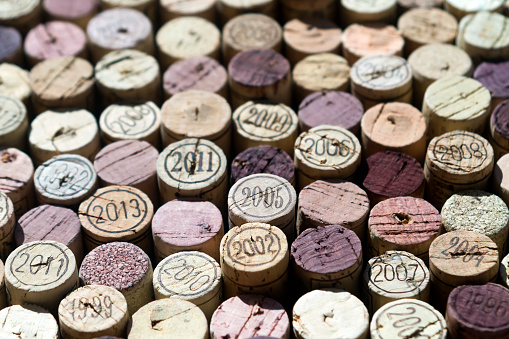 Close-up of used natural wine cork tops in sunlighy, some of them stained purple or marked with years of vintage