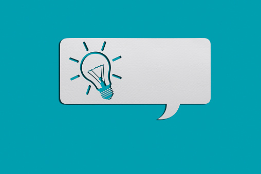 Yellow Idea Light bulb on a White speech bubble on blue background with clipping path. Horizontal composition with copy space. Creativity and innovation concept.