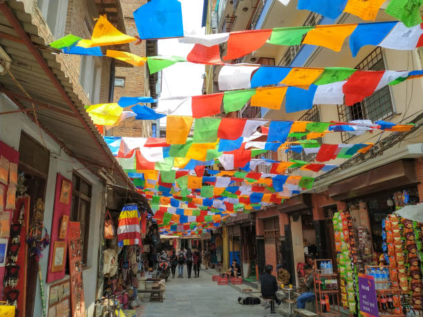 Shree Gha Bihar Road in Kathmandu Nepal, Kathmandu - April 21, 2019: View of Shree Gha Bihar Road in Thamel district of Kathmandu city. Colourful tibetan buddhist prayer flags waves above street with souvenir shops. thamel stock pictures, royalty-free photos & images