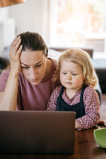 istock Mother working on laptop at home with little girl 1222462425