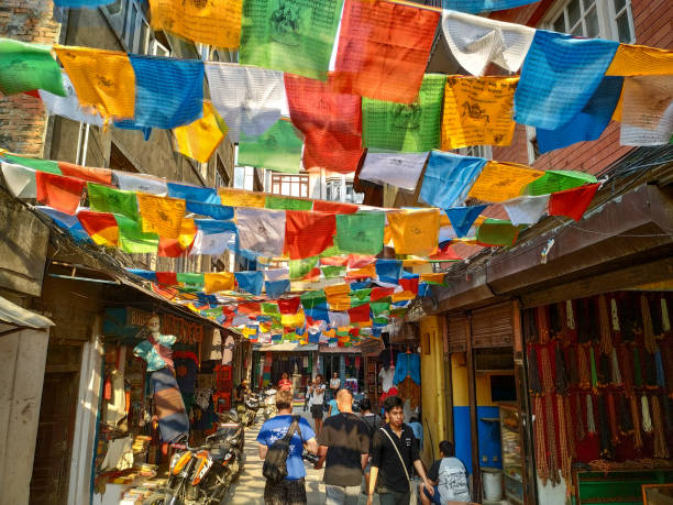 Shree Gha Bihar Road in Kathmandu Nepal, Kathmandu - May 09, 2019: View of Shree Gha Bihar Road in Thamel district of Kathmandu city. Colourful tibetan buddhist prayer flags waves above street with souvenir shops. kathmandu stock pictures, royalty-free photos & images