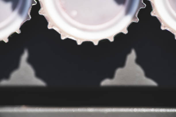 Three bottle tops beside one another, resting on a metal table.