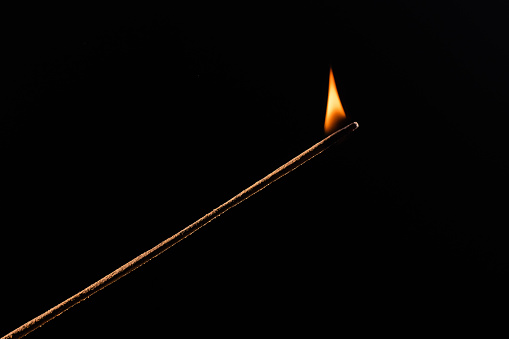 Match flame over black background, close up Macro fire burning on matchstick. Wooden matches with red sulfur heads, fire ignition match. Idea spark as leadership bring fire to team