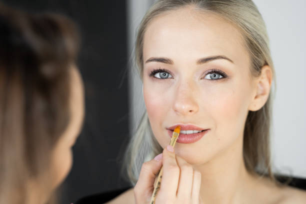 istock Makeup artist paints lips of model in studio 1222463499